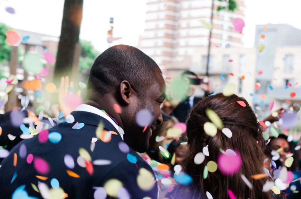 Multicultural couple wedding day bride and groom confetti.